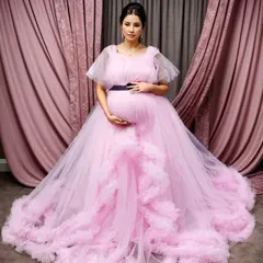 Pure elegance in our light pink ruffle gown. The sheer puff sleeves and cascading ruffles along the front create a soft, romantic look perfect for a baby shower or a sophisticated maternity photoshoot.