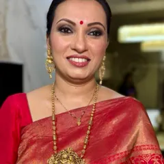 A radiant, smiling portrait. The makeup enhances her warm smile, with a focus on glowing skin and a classic lip color that brightens her entire face.