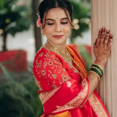 A closer look at Madhavi's bridal makeup. The focus is on flawless skin and eyes that sparkle, complemented by a traditional nath and gold jewellery.