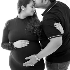 A tender moment captured in a timeless black and white style. This pose is perfect for showcasing the couple's bond during their pregnancy journey.