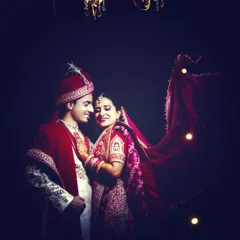 A royal-looking indoor wedding portrait, using dramatic lighting to create a rich and elegant photograph.