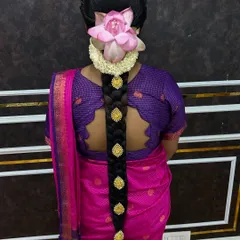This is my specialty, an intricate 'poola jada' or floral braid. Here, a traditional braid is adorned with jasmine flowers and a fresh lotus, creating a truly divine look for a South Indian bride.