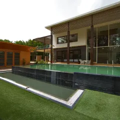 The pool area of the Sachdeva Farmhouse is a multi-level experience. The gym and spa open directly onto this central zone, with steps leading up to a terrace garden, creating a fluid connection between leisure, wellness, and nature.