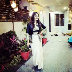 One of my happy clients looking radiant in a custom Indo-western outfit. This ensemble pairs a draped dhoti-style skirt with a sequined crop top and a structured jacket, perfect for a wedding reception or cocktail event.