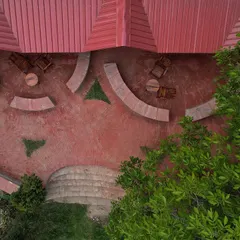 An aerial view of the outdoor seating area at Sargakhet, showing the concentric brick flooring and stone benches that complement the natural landscape and the restored heritage building.