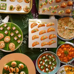 A magnificent top down view of a festive spread, perfect for any grand celebration. It showcases a wide array of my offerings, from bite sized appetizers and mini samosas to paneer curry and fresh salads.