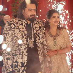 The grand entrance is a moment to remember. I designed this groom's black bandhgala jacket with dense, elegant white floral embroidery to create a powerful visual that stands out while perfectly matching the bride's celebratory glow.