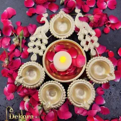 This beautiful urli and diya set features a central bowl surrounded by six diyas, flanked by two intricately designed peacocks. It is a stunning, all-in-one centerpiece for your festive decorations.