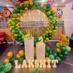 A closer look at the jungle animal theme, showing the detailed cake stand and props. The vibrant green balloon decor and animal foil balloons bring the wild safari adventure to life for the party.