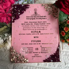 The invitation text is printed in gold on a glittery baby pink base, creating a soft and luxurious look for a wedding announcement.