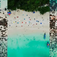 A creative, top-down drone shot of a beach in Thailand, framed to create an artistic composition. This view highlights the patterns of people, umbrellas, and boats against the sand and sea.