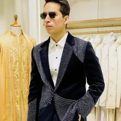 The full look of the navy velvet embroidered tuxedo. Paired with a crisp white shirt, it creates a powerful silhouette that balances intricate detail with classic formalwear structure.