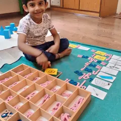 A child works with the movable alphabet to build words based on phonetic sounds. This hands-on approach to spelling and reading makes the process of learning language intuitive and enjoyable.