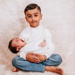 Even when the little one is a bit fussy, the big brother's patience and care shine through. I photograph the real moments, not just the perfect smiles.