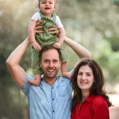 An outdoor family portrait doesn't always have to be formal. This shot captures a happy, relaxed family enjoying a moment together in nature, with their son perched happily on his father's shoulders.