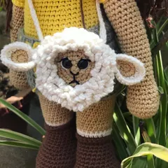 This is a special little lamb bag I created. It's a functional accessory, perfect for carrying small items, and also a unique piece of wearable art. The fluffy texture of the lamb's wool is created with a special loop stitch.