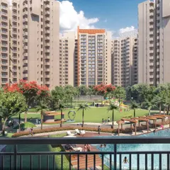 An elevated view of a large central green in a Greater Noida housing project. The landscape design includes a large swimming pool, pergolas, and pathways inspired by a Formula One track, tying all zones together.