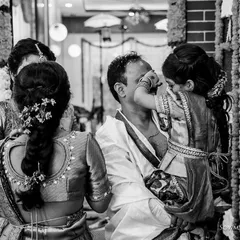 A tender, candid black and white moment of a child touching her father's face during a ceremony. These unscripted interactions are the heart of our documentary photography style, capturing pure love.