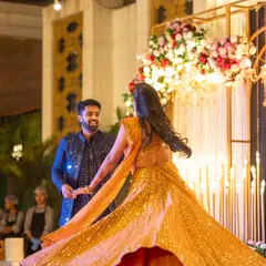 A bride's joyful twirl on the Sangeet stage. The golden lehenga shines under the stage lights, a moment of pure elegance and happiness that I help create through careful planning of lighting and stage design.