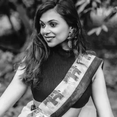 A beautiful black and white close-up, capturing the model's happy expression and the details of her modern saree and jewelry.