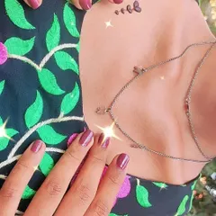 A tiny, delicate butterfly tattoo on the collarbone. This is a perfect example of how henna can be used for subtle and modern body art.
