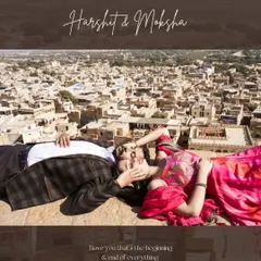 A unique aerial-view perspective of a couple relaxing on the ramparts of a Jaisalmer fort, with the sprawling golden city below them, blending history with a modern love story.