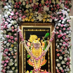 This close-up shows the detail in our floral frames. A beautiful mix of roses in different colors, combined with delicate baby's breath, creates an elegant and devotional decoration for this Krishna portrait.