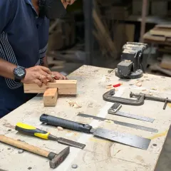 A classic woodworking scene: a workbench with chisels, a mallet, and a half-lap joint in progress. This is the heart of our hand tool joinery workshop, focusing on precision and technique.