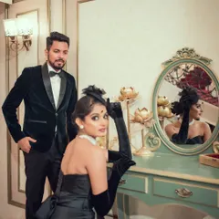 A classic vintage-style portrait of a couple. The woman looks into an ornate mirror while the man stands beside her, creating a scene that feels both romantic and mysterious.