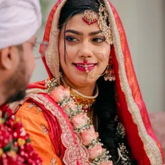 The bride looks at her groom with a loving smile. This close-up captures the emotion of the moment and the beautiful details of her bridal jewelry and makeup.