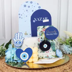 I love creating gifts that are both trendy and meaningful, like this Evil Eye themed Rakhi hamper. It’s designed to offer protection and good vibes, combining a bubble candle, a beautiful Rakhi, and other coordinated items on a golden platter, all centered around the popular Nazar theme.