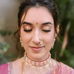 A close-up of Shalmali's classic bridal makeup. I focused on creating a neutral gold eyeshadow that beautifully complemented the zari of her Paithani saree and her skin tone. This is my signature minimal approach, ensuring every detail is balanced and graceful, especially in natural daylight.