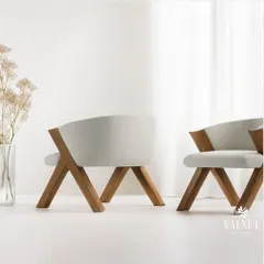 This natural wooden chair, with its clean lines and soft white upholstery, is a perfect blend of modern elegance and earthy charm. The unique cross-legged frame showcases our commitment to creating sculptural yet functional furniture.