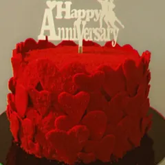 My classic red velvet cake is a popular choice for anniversaries. This design is covered in rich red velvet crumbs and edible hearts, making it a simple yet passionate statement of love.
