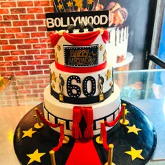 A glamorous three-tier Bollywood-themed cake for a 60th birthday bash. Featuring a red carpet, film reels, and golden awards, this cake was the star of the show, celebrating a lifetime of memories with cinematic flair.