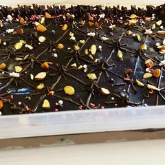 This is my Brownie Delight, a showstopping dessert for any party. It's a tray of my fudgy brownies covered in a rich chocolate ganache, nuts, and sprinkles.