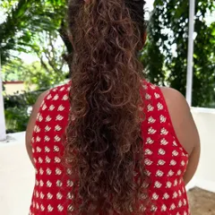 Holding up the curls to show the length and the beautiful, springy texture we achieved with this corrective cut and color.