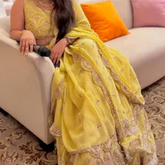 A happy client enjoying a function in a beautiful yellow lehenga, perfect for a Haldi or Sangeet ceremony.