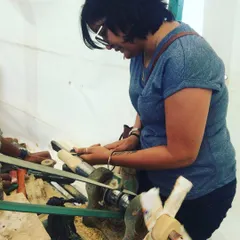 A visitor completely absorbed in the process of shaping her first piece of wood. The hands-on workshop is a chance to disconnect and focus on creating something beautiful with your own hands, learning a new skill along the way.