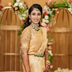 This bride looks absolutely stunning in her gold Kanchivaram saree for her engagement. The custom-designed blouse with delicate embroidery adds a touch of elegance to her look.