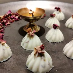 Here is a closer look at my Rasmalai-flavored white chocolate modaks, garnished with dried rose petals. These are one of my most popular fusion flavors, combining the taste of a classic Indian sweet with fine chocolate.