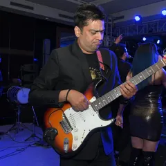A guitarist lost in the music during a live band performance. I enjoy capturing these moments of intense focus and passion from musicians on stage.