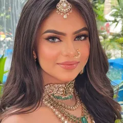 A closer look at the royal red bridal glam. You can see the smooth, airbrushed finish of the skin and the perfectly defined brows that frame the face.