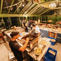 A wide-angle, behind-the-scenes shot of our team in action in a beautiful glasshouse kitchen. This image captures the scale and energy of our operations during a live event.