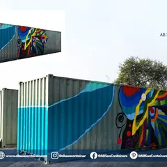 A shipping container serves as a blank canvas for creativity. This container features vibrant, custom-painted artwork, turning an industrial object into a piece of public art for an event.