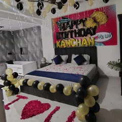 A surprise birthday decoration for a partner, with black and gold balloons, a custom banner, and "I ❤️ U" spelled out in rose petals on the floor.