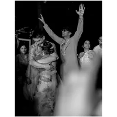 In the middle of the celebration, a quiet embrace. This black and white photo freezes a candid moment of connection between the couple, while the energy of the party continues around them.