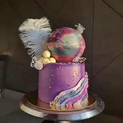 Isn't she gorgeous? I made this dreamy cake for a little girl who loves pink and purple. It features a galaxy-like chocolate sphere, delicate butterflies, and a white feather for a magical touch.
