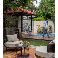 Here we created a relaxed seating area adjacent to the pool, featuring curved lounge chairs and a small coffee table. In the background, a poolside bar under a gazebo and a beautiful tree mosaic wall add layers of function and artistry to the space.