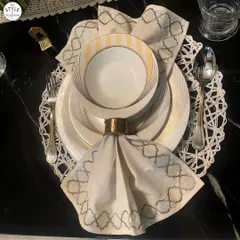 Elegantly arranged crockery atop a crisp, folded napkin creates a visually pleasing dining table. This place setting shows how attention to detail enhances the dining experience, combining functionality with aesthetics.